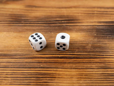 Dice on a dark wooden background. Playing dice on a wooden table. close upの写真素材