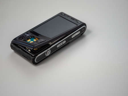Old push button mobile phone. Broken phone. Phone on a gray background.の写真素材