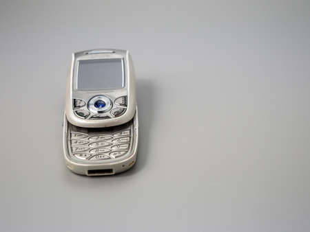 Old push button mobile phone. Broken phone. Phone on a gray background.の写真素材