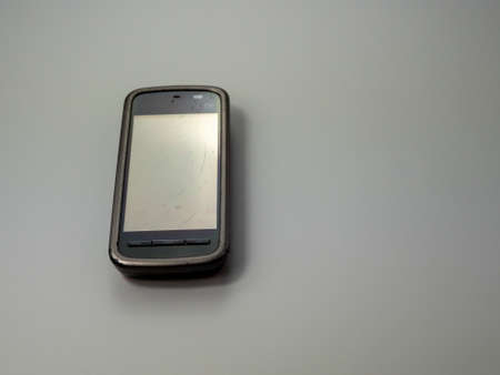 Old smart phone. Broken phone. Phone on a gray background. Broken smartphone.の写真素材
