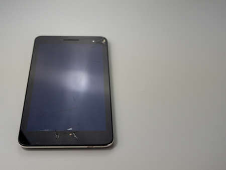 Old smart phone. Broken phone. Phone on a gray background. Broken smartphone.