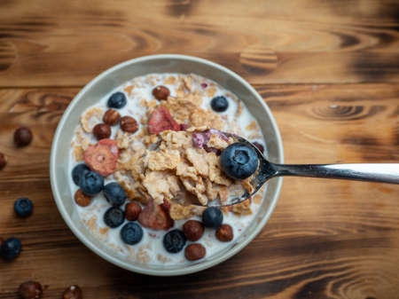 A cup with muesli and fresh berries on a wooden table. Healthy food, snack or breakfast. Healthy food.の写真素材