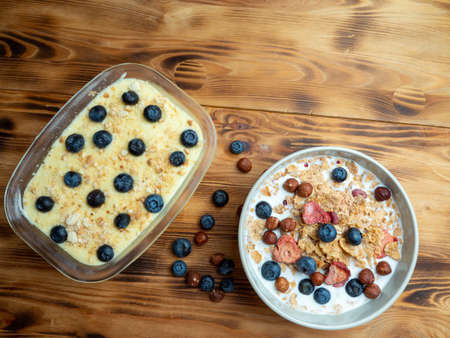 Cup with muesli and homemade cake on a wooden table. Healthy food, snack or breakfast. Close up.