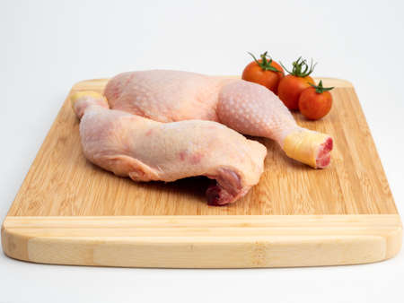Raw chicken legs on a cutting board. Chicken legs on a white background. Close up.の写真素材