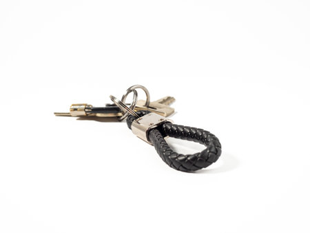 House key with a keychain on a white background. The concept of buying a house.の写真素材