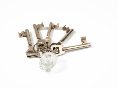 House key with a keychain on a white background. The concept of buying a house.