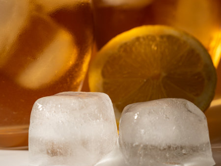 Background of ice tea in a glass with ice cubes. Ice tea with ice. Close up.の写真素材