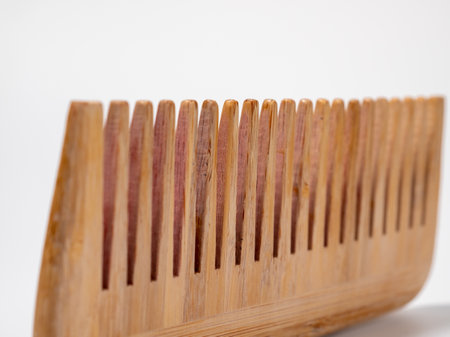 Wooden comb for hair on a white background. Close up.