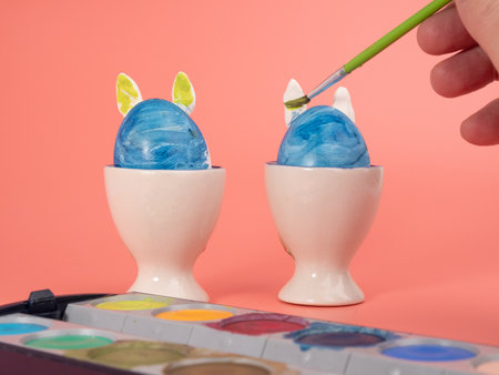 Coloring Easter eggs. Decorate eggs for Easter on a pink background. Eggs, brush and paint.の写真素材