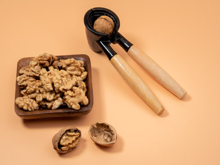 Walnut and nutcracker on orange background. Raw walnuts. Close up.の写真素材