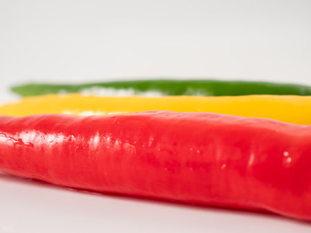 Red yellow and green chili peppers on a white background. Close up.の写真素材
