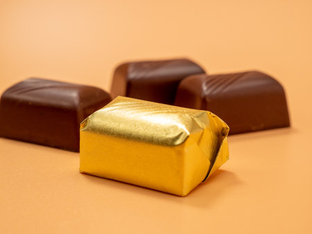 Chocolate candies on an orange background. Candy with filling. chocolates. Close up.の写真素材