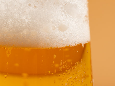 Glass of beer with foam. Mug of beer on an orange background. Close up.の写真素材