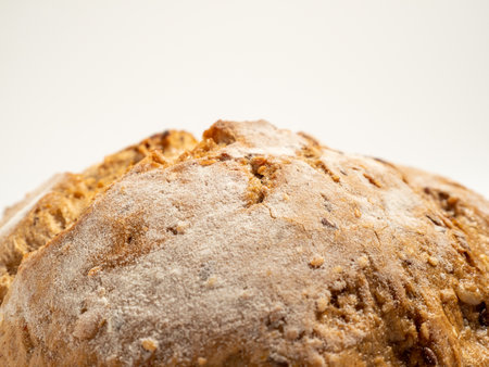 Dark bread on a white background. Round bread with grains. Close up.の写真素材