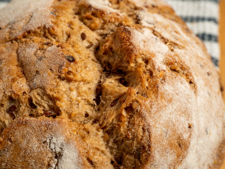 Dark bread on a wooden background. Round bread with grains. Close up.