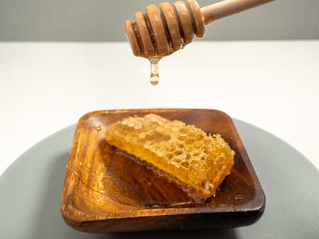 With honeycombs and a wooden spoon for honey in a wooden cup. Honeycombs and honey. Close up.