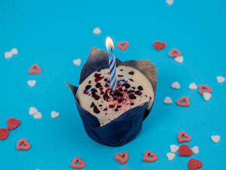 Muffin with a candle on a blue background. Holiday muffins. Close up.の写真素材