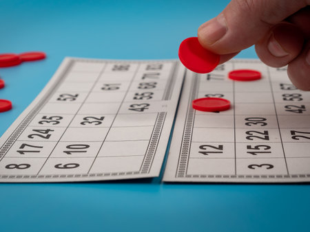Board game bingo. Plastic playing chips in hand. Close up.の写真素材