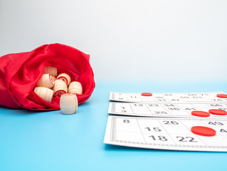 Board game bingo. Wooden barrels with lotto numbers, playing cards for the game. Close up.の写真素材