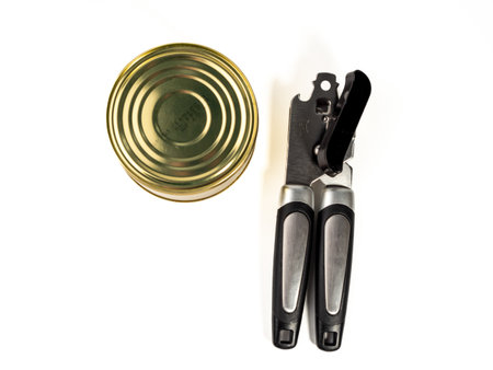 Can opener with tin can isolated on white background. Metal can opener. Close up.の写真素材