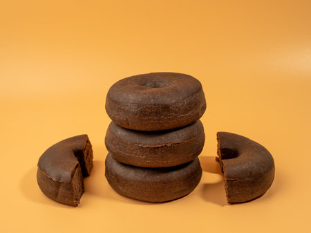 Fresh dark vegetarian donut on orange background. Close up.の写真素材