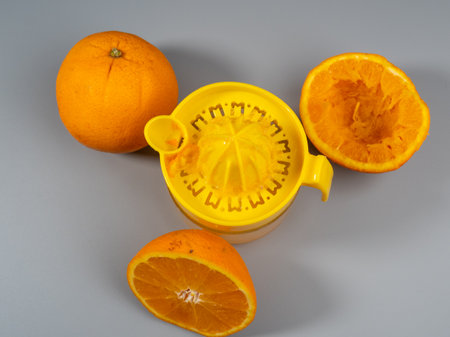 Orange juicer with ripe oranges. Fresh juice. Gray background.の写真素材