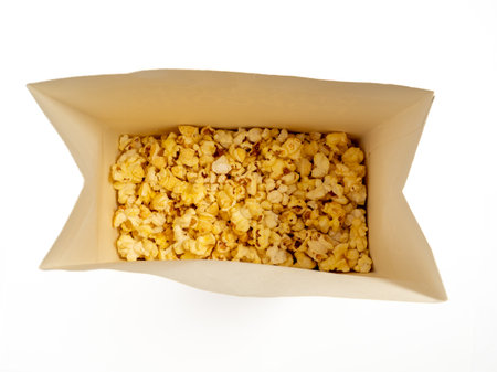Popcorn in a cardboard box on a white background. Sweet popcorn on white. Close up.の写真素材