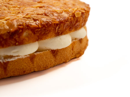 Bee sting cake, light cake with cream filling, with crispy almonds. Cake with almonds on a white background.の写真素材