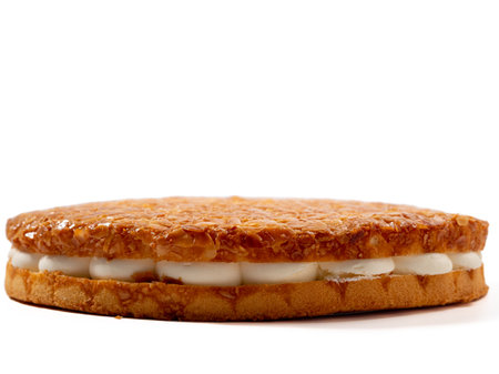 Bee sting cake, light cake with cream filling, with crispy almonds. Cake with almonds on a white background.の写真素材