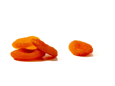 Wooden bowl of dried apricots on a wooden background, selective focus. Dried apricots close up.の写真素材