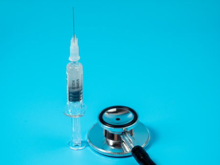 Injection vaccine on a blue background, medicine concept. On the syringe is applied: vaccination for adults and expiration date.の写真素材