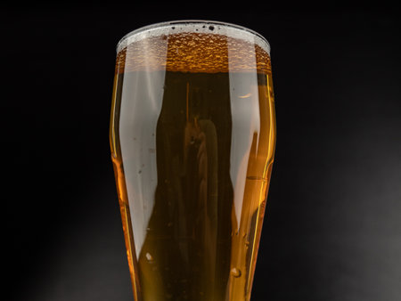 A glass of cold beer on a dark background. Glass of beer close up.の写真素材