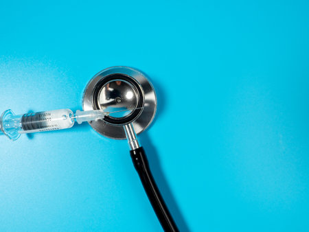 Injection vaccine on a blue background, medicine concept. On the syringe is applied: vaccination for adults and expiration date.の写真素材