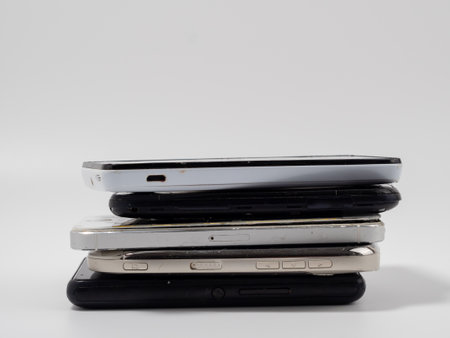Damaged mobile phones. A bunch of broken smartphones. Used phones on a light background.の写真素材