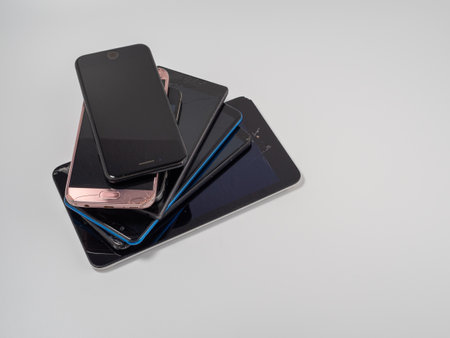 Damaged mobile phones. A bunch of broken smartphones. Used phones on a light background.の写真素材