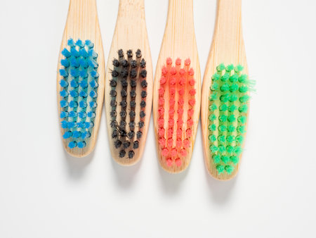 Bamboo toothbrushes in different colors. Wooden toothbrush on a white background. Toothbrush close up.の写真素材