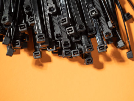 Plastic black ties on an orange background. Plastic ties for cables.の写真素材