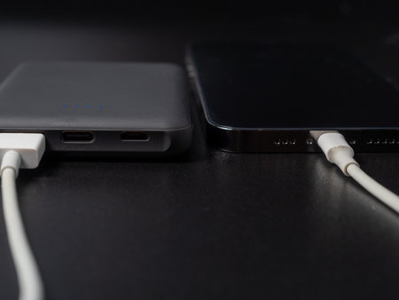 Power bank for charging mobile devices on a black background. Smartphone charger with power supply....