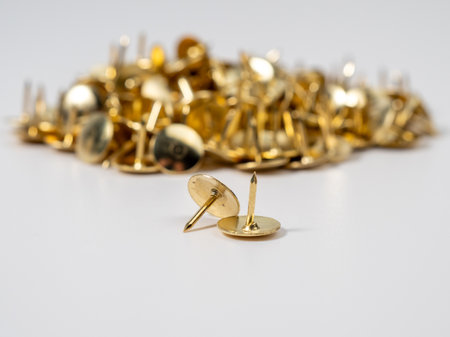 Pushpins of gold color on a white background. Push pins close up.の写真素材