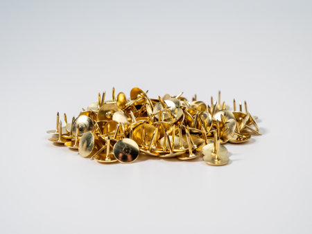 Pushpins of gold color on a white background. Push pins close up.の写真素材