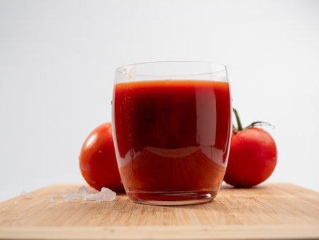 Glass of tomato juice and tomatoes on a white background. Freshly prepared tomato juice.の写真素材