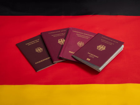 Passport of citizen of Germany on background of flag of Germany. Concept of obtaining German citizenship.の写真素材