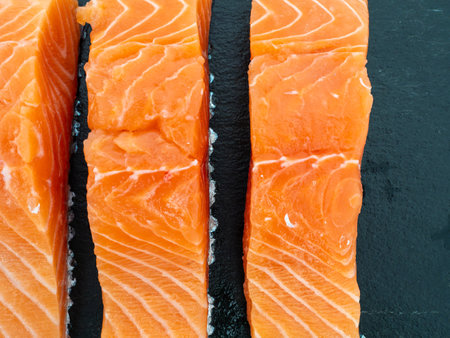 Salmon fish fillet on slate stone. Red fish fillet close-up on a white background.の写真素材