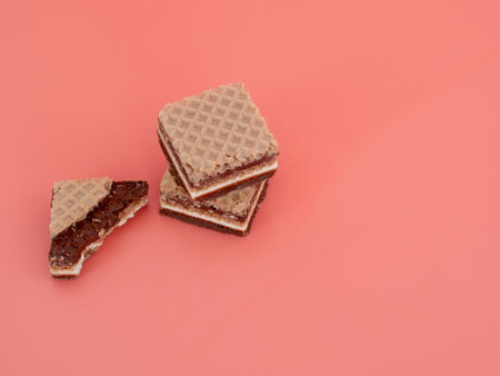 Delicious chocolate wafers with hazelnuts on a pink background. Wafers with chocolate and nuts.の写真素材