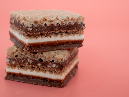 Delicious chocolate wafers with hazelnuts on a pink background. Wafers with chocolate and nuts.の写真素材