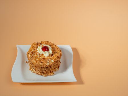 Butter cake with cherry filling on a bright orange background. Butter cake decorated with juicy cherries. A delicious butter cake topped with a single cherry on an orange surface.の写真素材