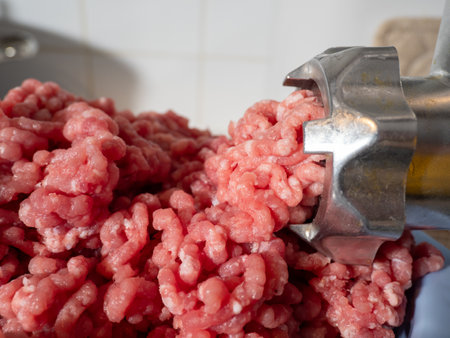 An electric meat grinder grinds meat into minced meat. Electric meat grinder close up