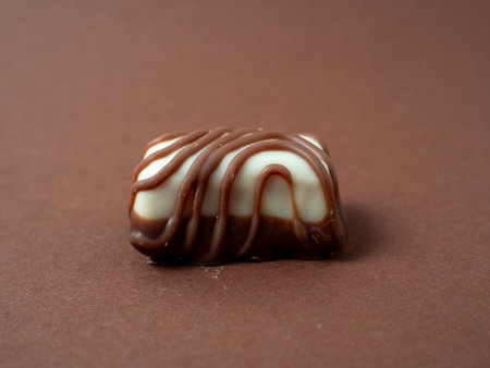 Chocolate candy arranged on a warm brown background. Chocolate candies close-up.の写真素材