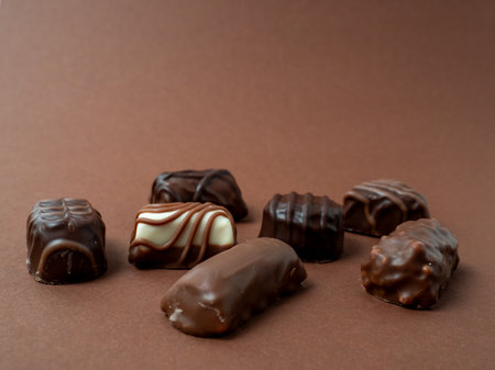 A variety of chocolates arranged on a rich brown background. Chocolate candies close-up.の写真素材