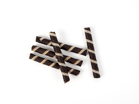 Crispy waffle rolls on a white background. Black and white wafer rolls close-up.の写真素材